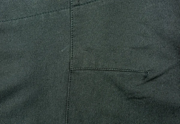 Giysi endüstrisinde kullanılan siyah kumaşa makine dikişleri..