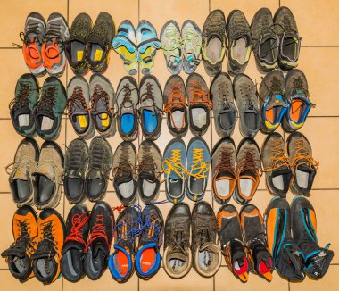 Niedomice, Poland - August 20, 2022: A collection of used mountaineering, approach and climbing shoes. Top view of various shoe models from several leading manufacturers in the outdoor market.
