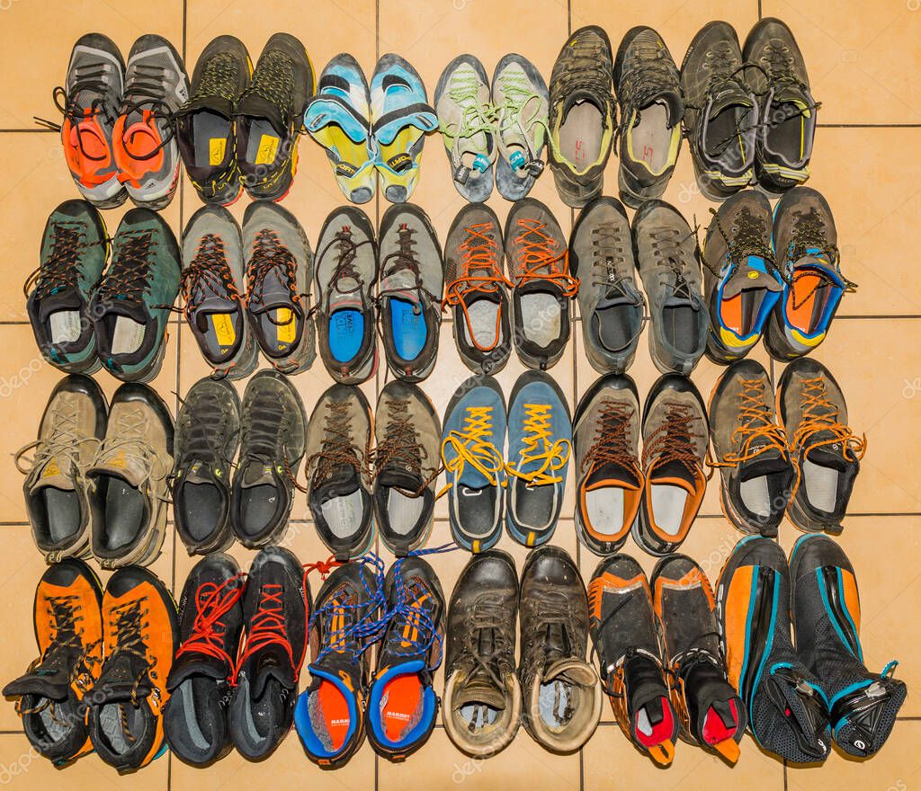 Niedomice, Poland - August 20, 2022: A collection of used mountaineering, approach and climbing shoes. Top view of various shoe models from several leading manufacturers in the outdoor market.