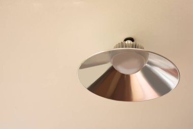 Silver ceiling lamp mounted on a cream colored ceiling