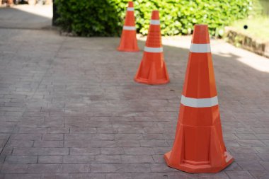 Turuncu trafik konisi özel bir alanda kısa süreli park için tuğla bir yol yüzeyine kurulmuş.