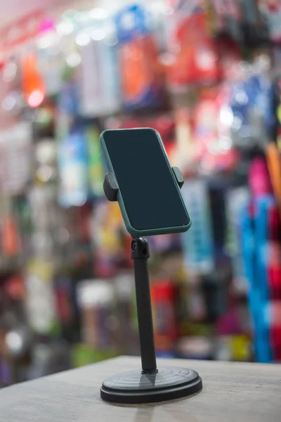 携帯電話は 製品を販売するライブ放送を準備するために店の背景を持つスタンド — ストック写真