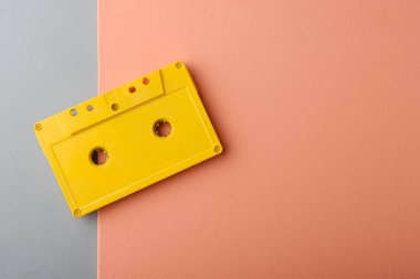 old retro cassette tape on a pink background. top view, close up photo.