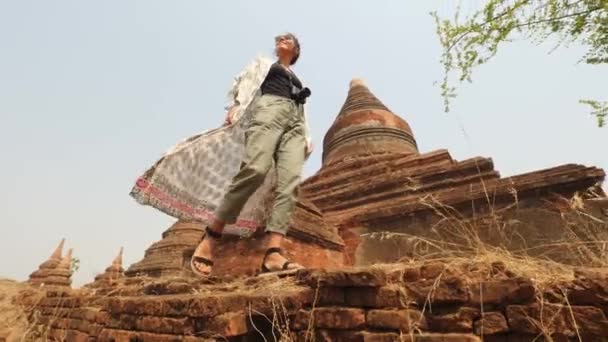 Giovane donna turistica che cammina lungo vecchi templi birmani tradizionali. Viaggi Vacanza Asiatica Natura Concetto Filmato. Filmato Steadycam 4K Slowmotion. Bagan, Myanmar. — Video Stock