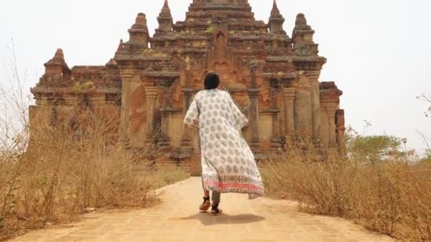 Junge Touristin macht ein Foto mit dem Handy des alten traditionellen burmesischen Tempels. Travel Adventure Lifestyle Vacation Konzept. 4K Slowmotion Schwebestativ Follow Me Footage. Bagan, Myanmar. — Stockvideo