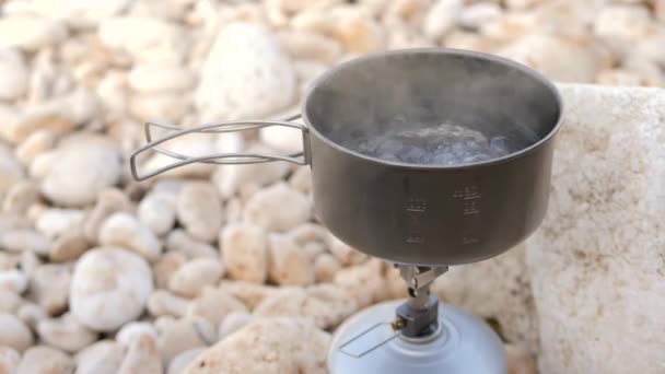 Acqua bollente in pentola di titanio leggera su stufa a gas. Cooking Outside Camping 4K concept — Video Stock