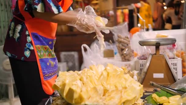 Vendedor de frutas pelando jaca en el mercado nocturno. Exotic Asian Tropical Fruits Street Food Concept. Phuket Town, Tailandia. Imágenes de vídeo 4K de alta calidad. — Vídeo de stock