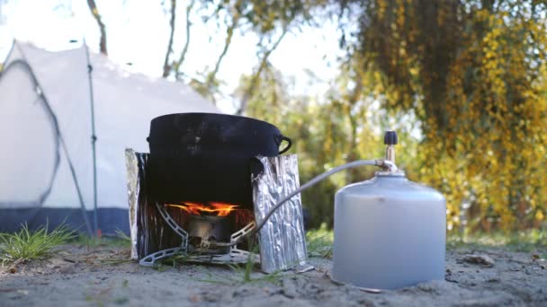 Matlagning mat i Camping Pot med hjälp av bärbar gas spis. Utanför är gratis 4K koncept — Stockvideo