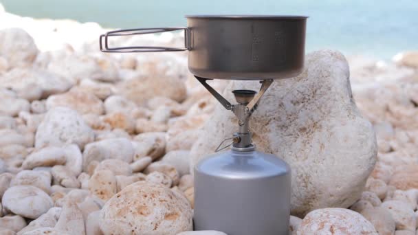 Pot Titanium Ringan di Gas burner Stove. Pemasak air mendidih di luar. Camping konsep 4K — Stok Video