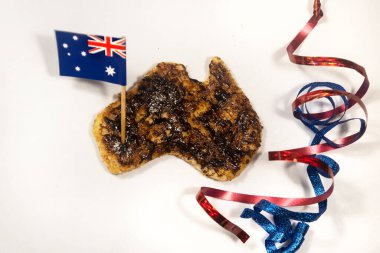 Avustralya usulü, Avustralya usulü, beyaz arka planda küçük, mavi ve kırmızı kurdeleli vegemite tostu..