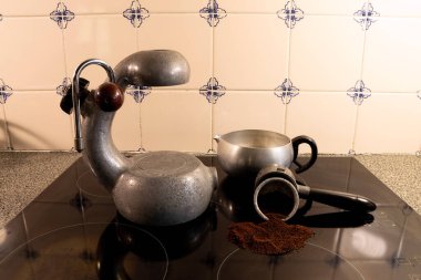 Antika İtalyan sobası atomik espresso kahve makinesi modern siyah cam ocağın üstünde..