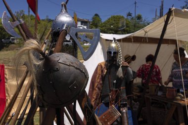 Yeniden yaratılmış ortaçağ Viking zırhı ve silahları ön miğfere özenle odaklanmış bir panayırda yeniden canlandırılıyor..