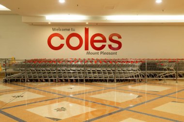Mackay, Queensland, Avustralya - Mayıs 2022; Coles Mount Pleasant mağazası tabelası ve önünde boş alışveriş arabaları var.