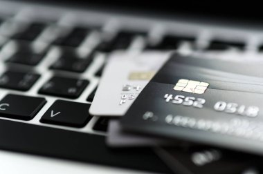 Bilgisayardaki kredi kartının çevrimiçi mağazalardan ve çevrimiçi alışveriş için yapılan ödemeleri yakından çek. İnternet alımı kavramı. Arkaplan için seçici odak