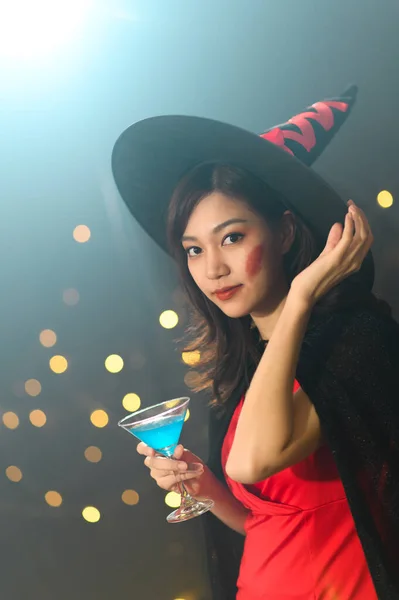 美丽的年轻亚洲女人的画像 穿着巫婆式夏洛瓦服的女人在夏洛瓦间派对上喝鸡尾酒 而不是黑暗魔法背景 节日派对的概念 — 图库照片