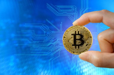 Arka planda şehir manzarası olan altın bitcoin elinde. Madencilik ya da engelleme teknolojisi. Yeni Sanal Para Konsepti.