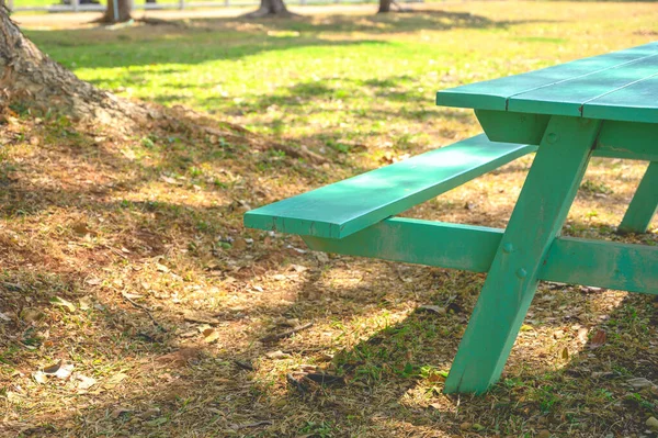 Sluiten Een Deel Van Groene Houten Picknickbank Onder Grote Boom — Stockfoto