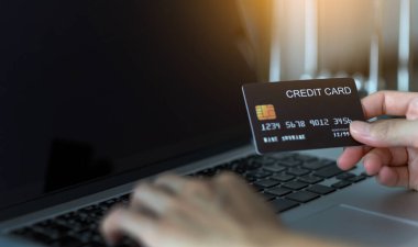 Kredi kartı tutan ve internetten bilgisayar alışverişi yapan kadınların ellerini kapat. E-ticaret, internet bankacılığı, kontrol bakiyesi, bankacılık hizmeti, kredi kartıyla ödeme, ödeme