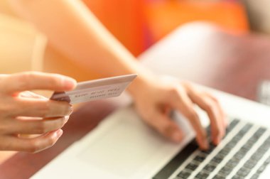 Kredi kartı tutan ve internetten bilgisayar alışverişi yapan kadınların ellerini kapat. E-ticaret, internet bankacılığı, kontrol bakiyesi, bankacılık hizmeti, kredi kartıyla ödeme, ödeme