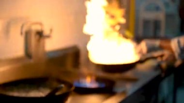 Profesyonel aşçı stili bulanık, Şef mutfak restoranında sebzeleri sebzeyle karıştırıyor.