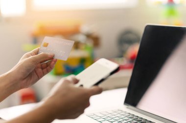 Kredi kartı tutan kadınların ellerini kapat ve online alışveriş yapmak için akıllı telefonu kullan. Cep telefonu ödemeleri, e-ticaret, internet bankacılığı, m-bankacılık, bankacılık hizmeti, kredi kartıyla ödeme
