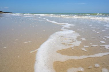 Kumlu sahil kıyısında yumuşak bir dalga. yaz tatili etkinliği arka plan kavramı