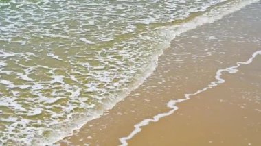 Kumlu sahil kıyısında yumuşak bir dalga. yaz tatili etkinliği arka plan kavramı
