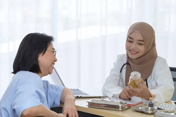 Jovem Mulher Asiática Muçulmano Médico Segurando Garrafa Pílulas Explicando Paciente — Fotografia de Stock