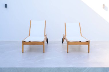 Açık havada beyaz duvarı olan iki modern güneş salonu. Yaz Tatili ve Tatil Yaşam Tarzları. Boşluğu kopyala