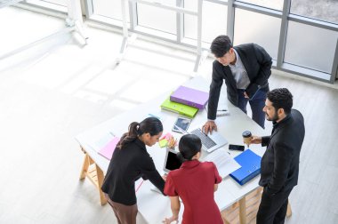İş adamları grup toplantısının en üst görüşü. Toplantı masasında proje planlama belgesi ile takım konferansında çalışan profesyonel iş kadınları ve işadamlarıyla hava görüşü