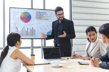 Businessman Giving Presentation Report to Business Team in the Conference Room, Shows Digital Information Graphics, Pie Charts about Company Growth on TV