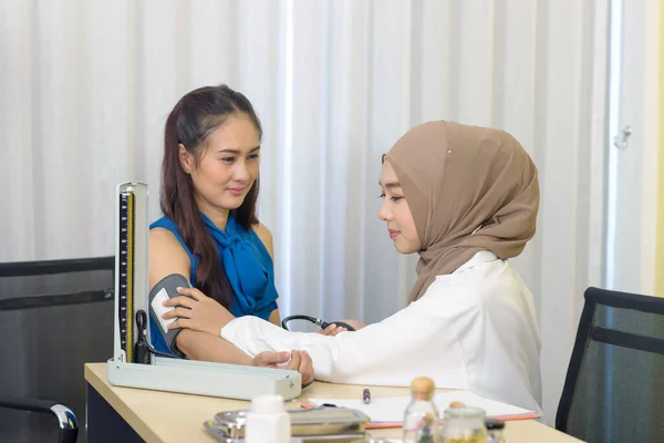 Mulher Muçulmana Médico Usando Esfigmomanômetro Verificando Pressão Arterial Para Jovem — Fotografia de Stock