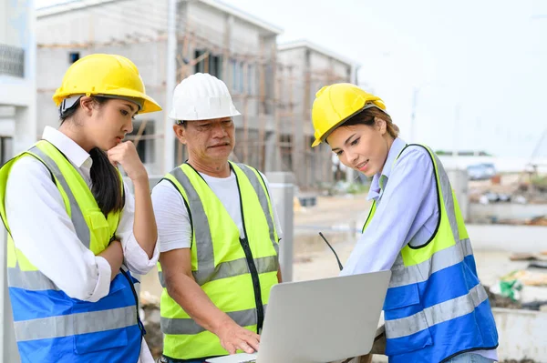 Group Contractors Engineers Formats Safety Vests Helmets Working Laptop Standing — Zdjęcie stockowe