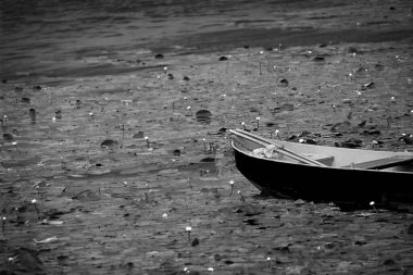 Gölde eski bir balıkçı teknesi. Siyah beyaz fotoğraf.