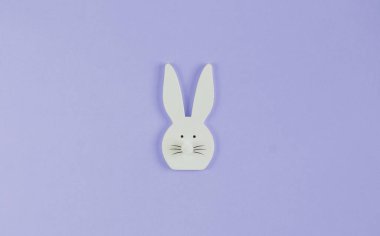 Mor arka planda beyaz ahşap tavşan. Tasarım için arka plan. Boşluğu kopyala.
