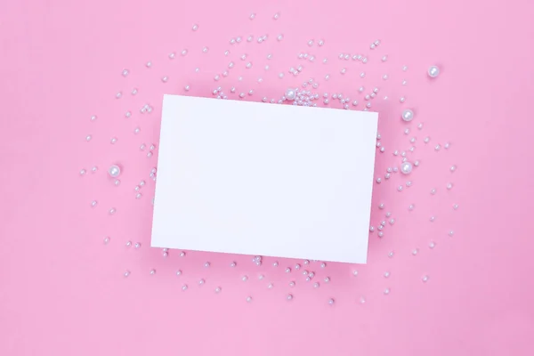 진주로 된 분홍색 배경에 흰색 카드. 복사 공간. — 스톡 사진