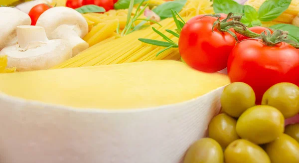 Parmesan, basil, mushrooms, cherry tomatoes, olives, rosemary and various types of pasta. Ingredients for making various paste tips. Italian cuisine.