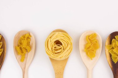 Different types of pasta on wooden spoons. A type of pasta. Copy space.