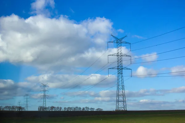 Power transmission lines in the field. High voltage power transmission towers.