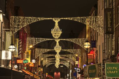 Dublin, İrlanda - 13 Kasım. 2021: Anne Caddesi 'ndeki Noel ışıklarının güzel akşam manzarası St. Ann' s İrlanda Kilisesi ve Grafton Caddesi 'ndeki mağaza tahtaları.