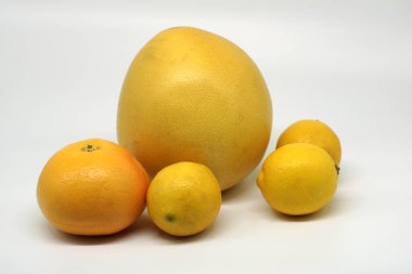 Bir grup sarı turunçgil. Bir greyfurt, bir hamur ve beyaz arka planda izole edilmiş üç limon.