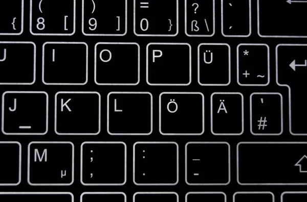 Close-up of a part of a black virtual keyboard with white backlit \'keys\'