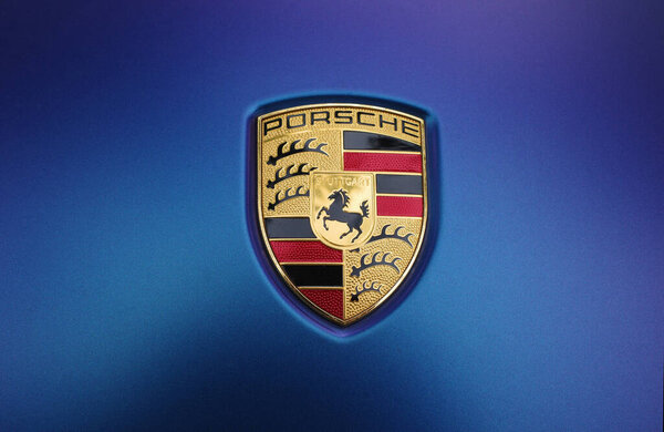 Amersfoort, the Netherlands - June 26, 2022: Close up of a Porsche sign on blue-purple metallic lack. The Porsche company was founded in 1931 with main offices in Stuttgart. The horse in the middle of the Emblem  comes from the coat of arms of Stuttg