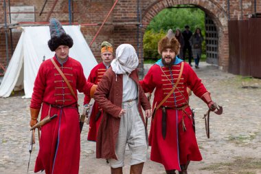 Moskova Rusya - 19 Eylül 2021: 17. yüzyılın tarihi festival avlusu. Krutitsky çiftliğinde tarihi yeniden yapılanma. Tarihi kostümlü askerler bir casus yakaladılar.. 