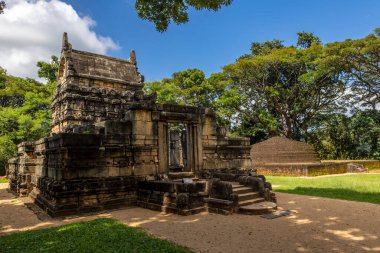 Sri Lanka. The ancient buddhist temple of Nalanda Gedige on a sunny day with a blue sky. There are beautiful green trees around the temple.