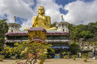 Sri Lanka. The golden Temple Dambulla. Front view on a sunny day. A large golden Buddha statue.