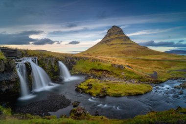 Batı İzlanda manzarası. Kirkjufell Dağı ve Kirkjulsfoss Şelalesi güzel günbatımında. Snaefellsnes yarımadasında bulunan ünlü İzlanda doğa manzarası