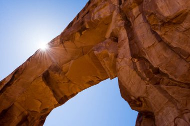 Güneş, Arches Ulusal Parkı 'ndaki Çam Ağacı Kemeri' nin arkasından bakıyor - Moab, Utah, ABD