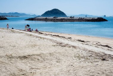 Matsuyama, Ehime ili, Japonya - 11 Nisan 2018: Kazahaya no-sato Fuwari 'deki güzel plajda dinlenen aileler