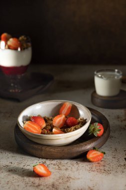 Yoğurtlu granola, süt ve taze ahududu, yaban mersini, beyaz mermer bir masada sağlıklı bir kahvaltı için mango. Yüksek kalite fotoğraf